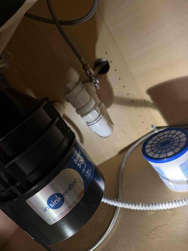 Completed annual VIP plumbing maintenance inspection of residential property. Inspected and documented basement plumbing infrastructure including main vertical PVC drain stack with aluminum foil tape wrapping secured by plastic straps, copper supply line T-junction connections with compression fittings, and circulation pump unit with rubber flexible connectors. Verified proper operation of kitchen sink garbage disposal system (InSinkErator unit) and under-sink water filtration canister with associated supply lines and shut-off valves. All components found operating within normal parameters with no leaks detected at time of inspection.