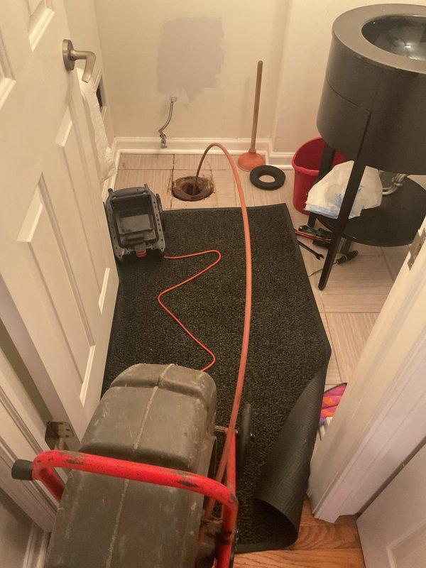 Responded to recurring flooding incidents affecting vanity sink and ground floor bathroom with toilet paper backup. Removed and reset toilet to access drain line after previous contractor reported tree root intrusion but provided unclear assessment regarding main line status. Performed comprehensive drain inspection and clearing to address blockage issue causing repeated overflow conditions in multiple fixtures.