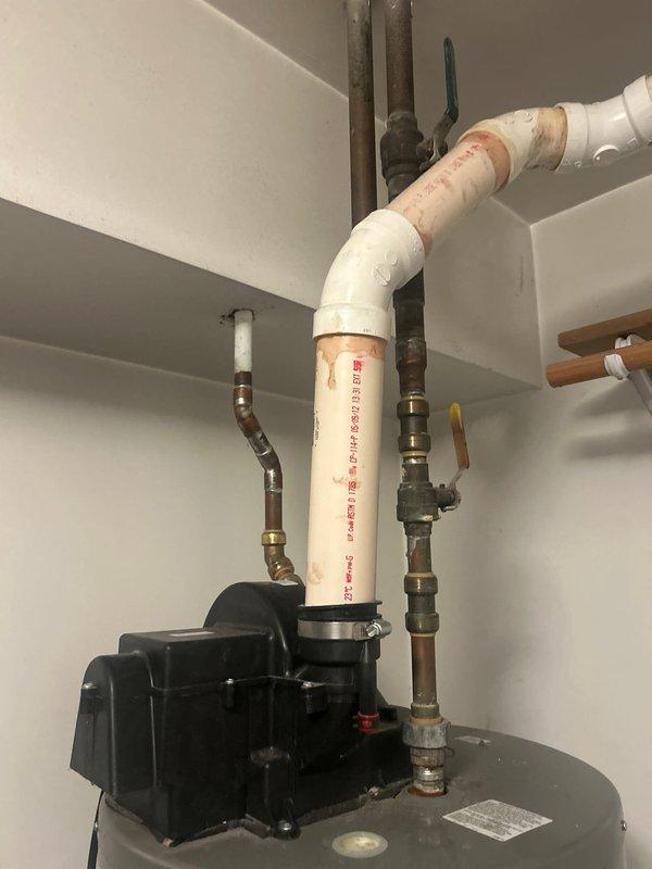 Performed comprehensive assessment of tanked water heater unit to determine eligibility status per customer request. Conducted thorough visual inspection of the water heater installation, examining the cylindrical tank unit, all supply and discharge piping connections, pressure relief valve assembly, and associated plumbing components. Evaluated condition of hot and cold water lines, including copper piping and PVC discharge lines with proper fittings and valve configurations. Inspected all brass connections at tank inlet and outlet ports for signs of corrosion, leakage, or deterioration. Documented current installation setup including electrical connections, safety warning labels, and overall unit condition through photographic evidence for assessment purposes.