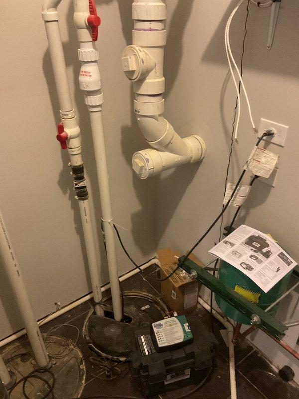 Performed comprehensive plumbing assessment of residential sump pump system and identified battery backup unit requiring replacement. Inspected existing pump installation with PVC discharge piping, ball valves, and electrical connections in utility room. Evaluated additional plumbing concerns including malfunctioning master bathroom tub faucet, non-operational jetted tub system, and defective shower head requiring repair or replacement.