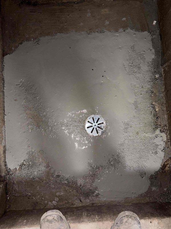 Performed concrete pour and leveling work for shower pan installation. Inspected and documented existing shower base condition, noting water drainage patterns and surface preparation requirements. Completed floor preparation work in adjacent workspace area, ensuring proper substrate conditions for plumbing fixture installation.
