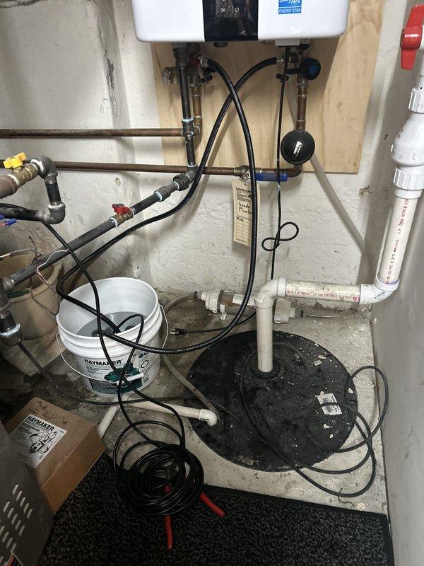 Completed annual tankless water heater flush and maintenance as part of preventative care package for 100-year-old residential property. System flushed using descaling solution to remove mineral buildup, with discharge collected in bucket as shown in documentation photos. Inspected all supply and return lines, verified proper operation of isolation valves, and confirmed adequate venting and combustion air supply. Unit tested post-flush with all parameters within manufacturer specifications and system operating efficiently with no issues identified.