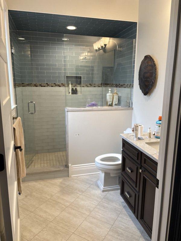 Responded to water leak service call and performed comprehensive plumbing inspection in residential bathroom and attic space. Located source of leak in drainage system within attic crawl space, where yellow PVC piping showed signs of moisture intrusion at connection points. Repaired compromised pipe joints and elbow fittings, ensuring proper seal and alignment of drainage lines. Verified all pipe hangers and mounting brackets were secure to wooden framing members. Inspected bathroom plumbing fixtures including walk-in shower enclosure, toilet, and vanity sink to confirm no additional leak sources or water damage present. All fixtures tested and confirmed operational with no active leaks detected upon completion.