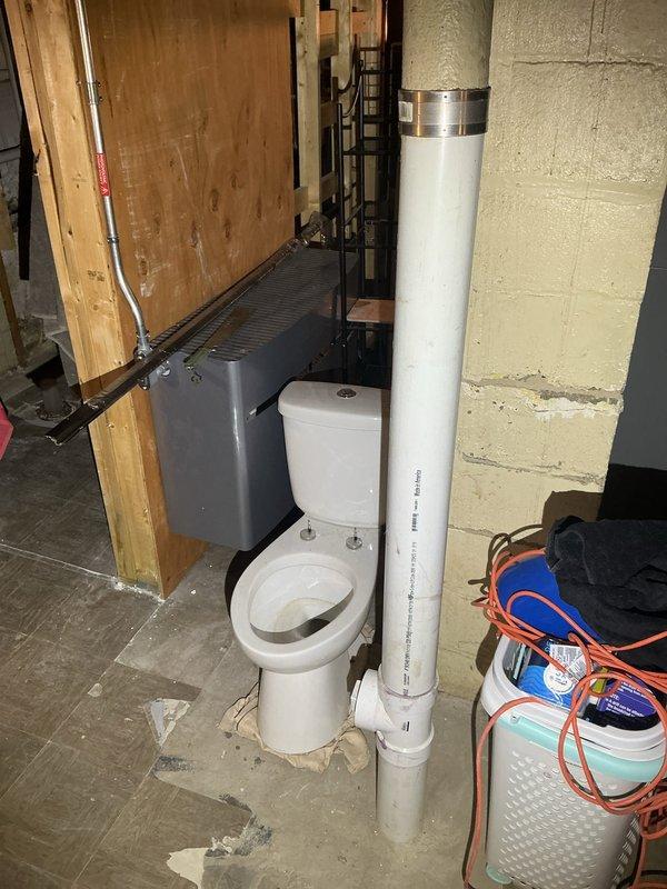 Conducted comprehensive assessment of unfinished basement for drain tile system installation and rough plumbing estimate. Inspected existing ejector pit system and evaluated extensive water intrusion damage evidenced by significant mold growth and dark staining along lower wall framing and concrete foundation. Assessed current plumbing configuration including partially installed toilet fixture, vertical PVC ventilation stack, and copper supply lines. Documented basement conditions showing active moisture issues requiring remediation, evaluated structural framing and concrete floor for drain tile installation feasibility, and photographed all relevant areas to prepare detailed estimate for interior perimeter drain tile system, ejector pit evaluation/replacement, and complete rough plumbing installation for bathroom fixtures.