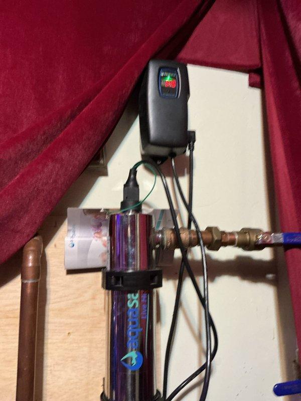 Completed comprehensive VIP maintenance inspection including tankless water heater, sump pump, and whole-home plumbing system evaluation. Inspected and verified proper operation of UV water purification system with clear housing showing active filtration media, confirmed electrical controls functioning correctly with illuminated indicators, and examined all copper piping connections and brass fittings for integrity. Tested ball valve operation, verified secure mounting of filtration components to wall backing, and confirmed power supply connections to UV purifier and control units were secure and operational.
