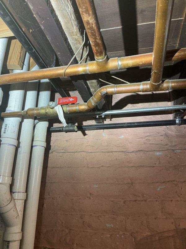 Inspected and documented existing plumbing infrastructure in crawl space and basement areas. The inspection revealed a mixed plumbing system consisting of copper supply lines, white PVC drainage piping, and older galvanized steel components. Copper piping showed typical patina and discoloration consistent with age but remained structurally sound with proper support brackets and connections. PVC drainage system appeared to be newer installation with appropriate slope and connection points. All visible pipe joints, valves, and fittings were examined for proper function and integrity. Photographs were captured to document current system configuration and condition for customer records.
