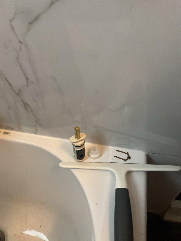 Responded to service call for dripping bathroom faucet. Disassembled single-handle tub/shower valve assembly and removed worn cartridge from chrome fixture mounted on marble-patterned tile wall. Replaced faulty cartridge, internal springs, and seals to eliminate leak. Reassembled valve assembly, tested operation for proper flow control and verified complete elimination of drip. System restored to full functionality.