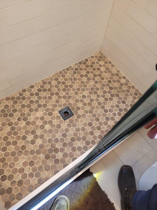 Responded to drain issue at residential property. Upon inspection, serviced kitchen sink drainage system and shower drain. Cleared blockage from kitchen sink P-trap assembly and verified proper water flow through dual-basin configuration. Inspected shower floor drain with hexagonal tile surround to ensure adequate drainage and remove any debris. Both fixtures tested and confirmed to be draining properly upon completion of service.