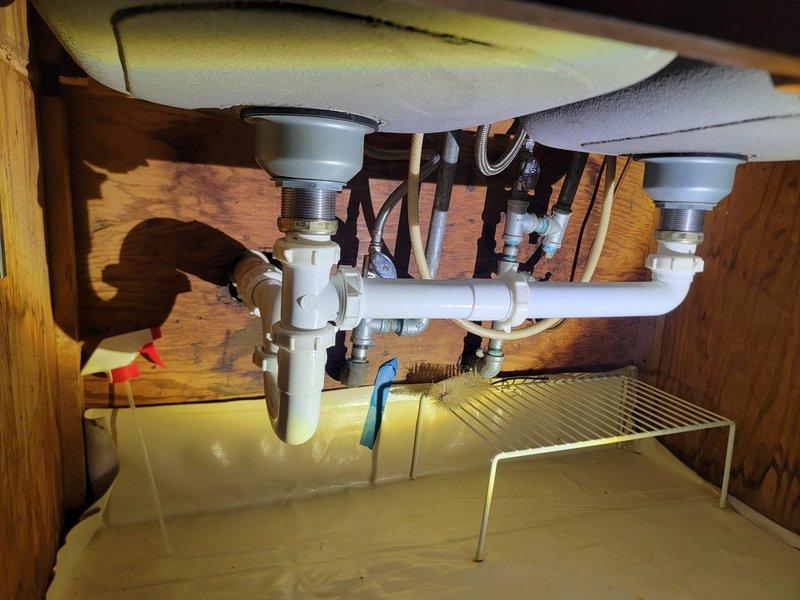 Responded to drain issue at residential property. Upon inspection, serviced kitchen sink drainage system and shower drain. Cleared blockage from kitchen sink P-trap assembly and verified proper water flow through dual-basin configuration. Inspected shower floor drain with hexagonal tile surround to ensure adequate drainage and remove any debris. Both fixtures tested and confirmed to be draining properly upon completion of service.