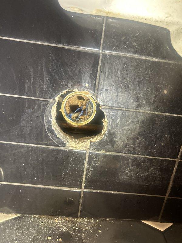 Responded to a clogged urinal fixture. Upon arrival, inspected the drainage system and identified blockage in the urinal waste line. Utilized drain cleaning equipment to clear the obstruction and restore proper flow. Verified fixture drainage functionality and confirmed complete resolution of the clog. Documented existing conditions including floor drain with mineral deposits and wear around plumbing connections.