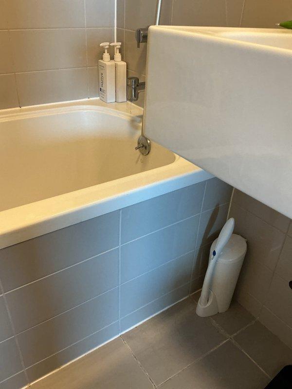 Responded to reported leak from bathroom to unit below. Inspected bathtub drain assembly and overflow system, replaced deteriorated drain seal and overflow gasket to eliminate water penetration. Tested valve connections for leakage and confirmed proper operation. Removed old caulking around bathtub perimeter and applied fresh silicone sealant to prevent water intrusion. Conducted water flow test to verify repairs resolved leak issue.