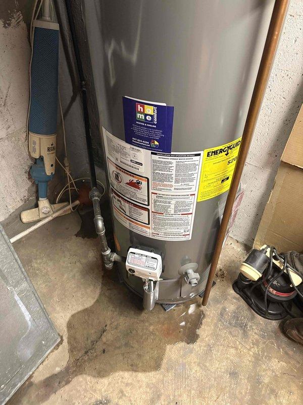 Installed new residential water heater in basement utility area. Removed existing unit and positioned replacement tank on concrete floor. Connected copper supply lines and PVC discharge piping to top of unit. Installed pressure relief valve and configured control box assembly at base. Verified all plumbing connections were secure and tested system for proper operation and absence of leaks.