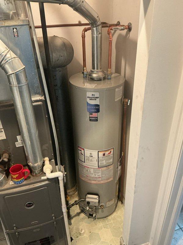Responded to service call for inadequate heating on residential tank-style water heater. Upon arrival, inspected Bradford White/Reliance brand water heater approximately five to ten years old located in utility closet alongside HVAC equipment. Conducted diagnostic assessment of heating performance and examined all visible components including copper supply lines, temperature and pressure relief valve connections, and gas control valve assembly. Verified proper plumbing connections and checked for any signs of sediment buildup or mechanical failure affecting heating capacity. Documented equipment condition with photographs showing unit specifications, manufacturer labels, and installation configuration. Provided customer with findings and recommended service options to restore optimal water heating performance.