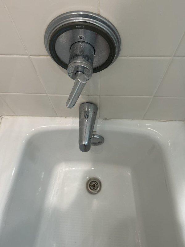 Responded to water leak service call and conducted thorough inspection of bathroom plumbing fixtures. Examined Kohler shower assembly including chrome faucet, diverter valve, and associated trim components mounted on tiled shower wall. Inspected porcelain bathtub fixture and drain assembly for signs of moisture intrusion or active leaking. Checked ceiling-mounted ventilation grille and surrounding areas for water damage or staining that could indicate leak source from above. All fixtures appeared functional with minor water spotting consistent with normal use. No active leaks detected during inspection period.