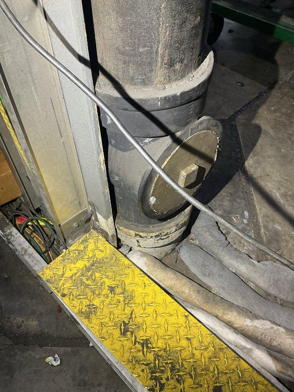 Conducted commercial storm drain system assessment for 8-inch cast iron piping running from rooftop to ground level concrete base. Identified active leak points at the base connection where the vertical drain pipe meets the concrete floor, documented existing conditions with detailed photography showing the drain assembly, flexible connector sections, and surrounding mechanical infrastructure. Provided estimate for necessary repairs to address water infiltration at the foundation-level connection points.