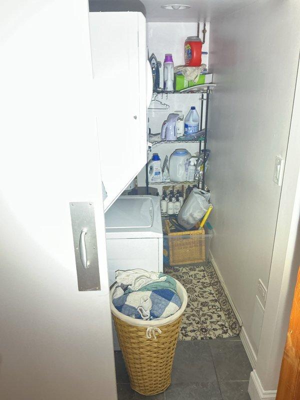 Conducted on-site drain and sewer estimate for residential property. Inspected utility closet area with concrete flooring and identified wall access panel with exposed insulation, indicating potential plumbing access point for future work. Evaluated adjacent laundry room containing washing machine and assessed drainage system accessibility for potential sewer line service or repair needs.
