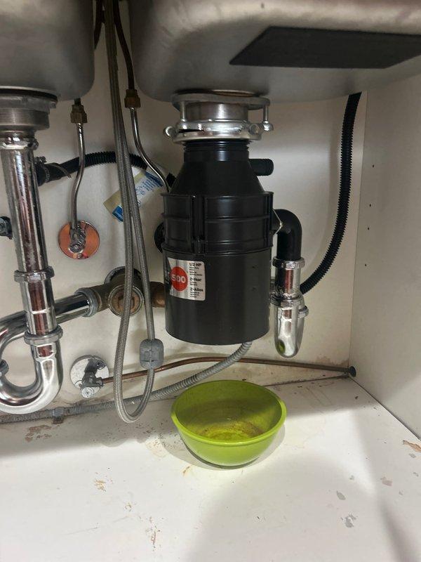 Completed installation of new garbage disposal unit under kitchen sink with proper mounting and plumbing connections. Unit was securely attached to sink drain flange, P-trap assembly was connected, and all drainage lines were properly configured to ensure leak-free operation. Provided customer with manufacturer's guide detailing acceptable and prohibited items for disposal, including approved food waste such as fruit peels, vegetables, small bones, and pasta, while highlighting items to avoid such as cooking oils, grease, and non-food materials.