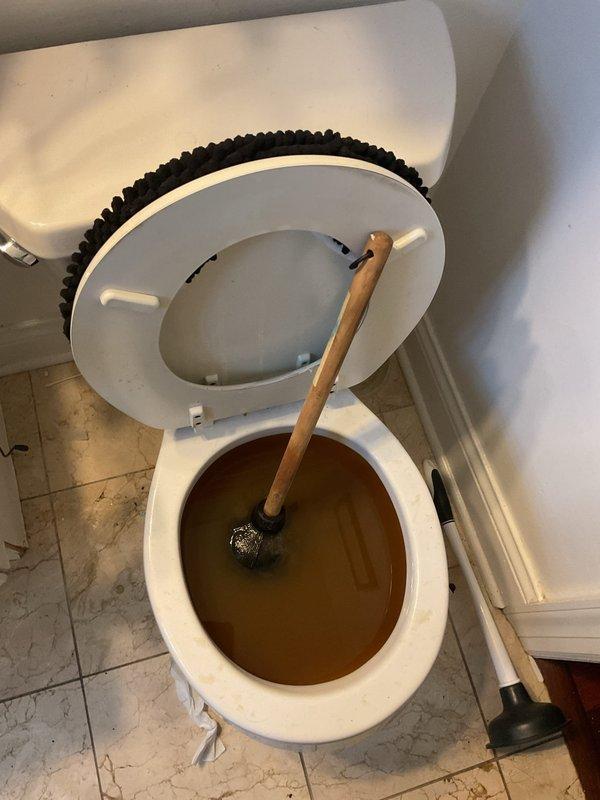 Responded to a clogged toilet service call and successfully cleared the blockage using a plunger. Upon arrival, found the toilet bowl filled with dark, murky water indicating a complete obstruction in the drain line. Applied proper plunging technique to dislodge the clog, restoring normal water flow and drainage function. Tested the toilet flush mechanism multiple times to confirm the blockage was fully cleared and proper operation was restored.
