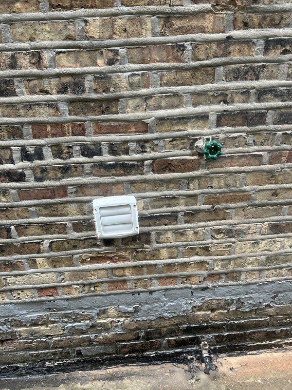 Responded to service call for non-functional exterior faucet. Upon inspection, determined existing hose bib had failed and required complete replacement. Accessed water supply line through interior wall cavity, requiring strategic opening of drywall to reach copper piping behind brick exterior. Shut off main water supply and removed deteriorated outdoor spigot assembly from exterior brick wall. Installed new frost-free hose bib with proper pitch for drainage, ensuring secure mounting through brick veneer into structural framing. Soldered new connections to existing copper supply line, pressure tested system for leaks, and verified proper operation of new fixture. Restored water supply and confirmed no leaks at connection points or through wall penetration.