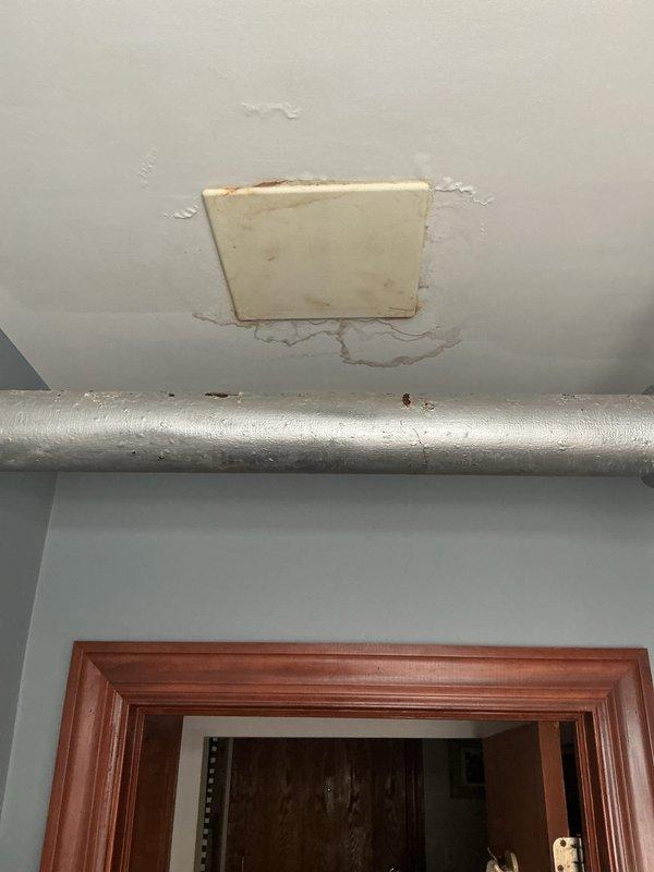 Responded to building water damage emergency during scheduled shutdown period. Upon inspection, identified active leak affecting ceiling and wall surfaces in mechanical utility area near HVAC equipment. Water infiltration had caused significant paint deterioration, bubbling, and separation from substrate, with exposed drywall visible in affected zones. Traced source of leak to compromised PVC piping running horizontally above damaged area. Isolated water supply, repaired defective pipe section, and verified system integrity through pressure testing. Applied temporary ceiling patch to contain damaged drywall area and prevent further deterioration until cosmetic restoration can be completed. Confirmed no water intrusion to adjacent HVAC heat exchanger components or associated metallic tubing. System restored to full operation following successful repairs.