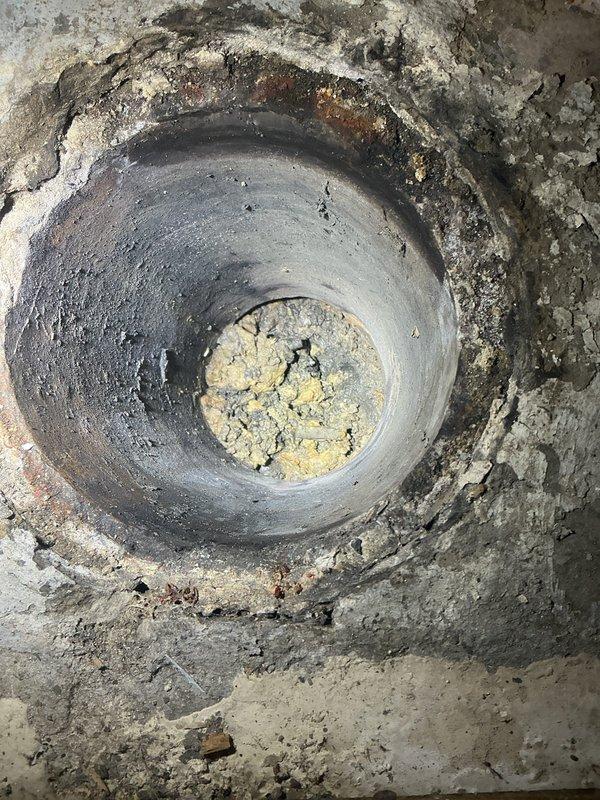 Responded to plumbing service call and performed comprehensive inspection of toilet and drainage system. Identified debris accumulation in floor drain opening and potential drainage concerns. Documented existing conditions of bathroom fixtures including toilet, shower enclosure, and plumbing connections. Presented repair options and sold necessary plumbing services to address drainage issues and ensure proper system function.