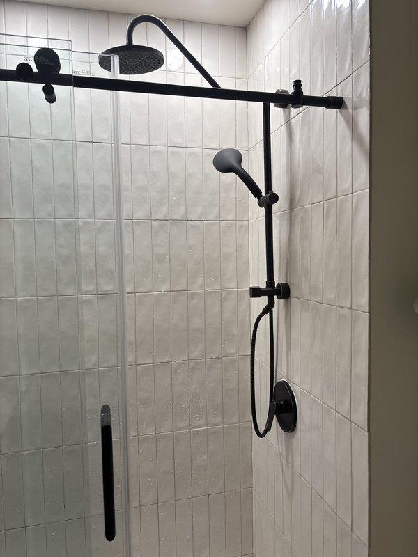 Responded to complaint of extremely low water pressure in upstairs shower, with hot water reduced to barely a trickle and cold water flow significantly restricted, while adjacent sink maintained normal pressure. Accessed shower valve assembly by creating opening in tile wall to diagnose pressure restriction issue. Upon inspection, identified pressure-balancing valve as source of flow limitation. Replaced faulty shower valve cartridge and pressure-balancing mechanism to restore proper water flow to both hot and cold water lines. Tested system operation to verify adequate pressure restoration and proper temperature control function. Completed installation with all fixtures operational and water pressure normalized throughout the shower system.