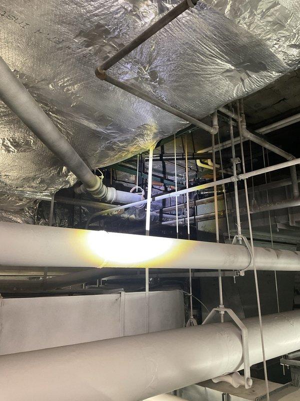 Responded to service call for drainage system not functioning properly. Upon inspection, accessed mechanical room and utility space to evaluate plumbing infrastructure and drain lines. Examined extensive network of PVC piping, ductwork, and valve assemblies throughout the mechanical space. Verified proper operation of manual shutoff valves and inspected flanged connections on large-diameter drain pipes. Cleared obstruction in drainage system, restoring proper flow and function to all fixtures. System tested and confirmed operational upon completion.