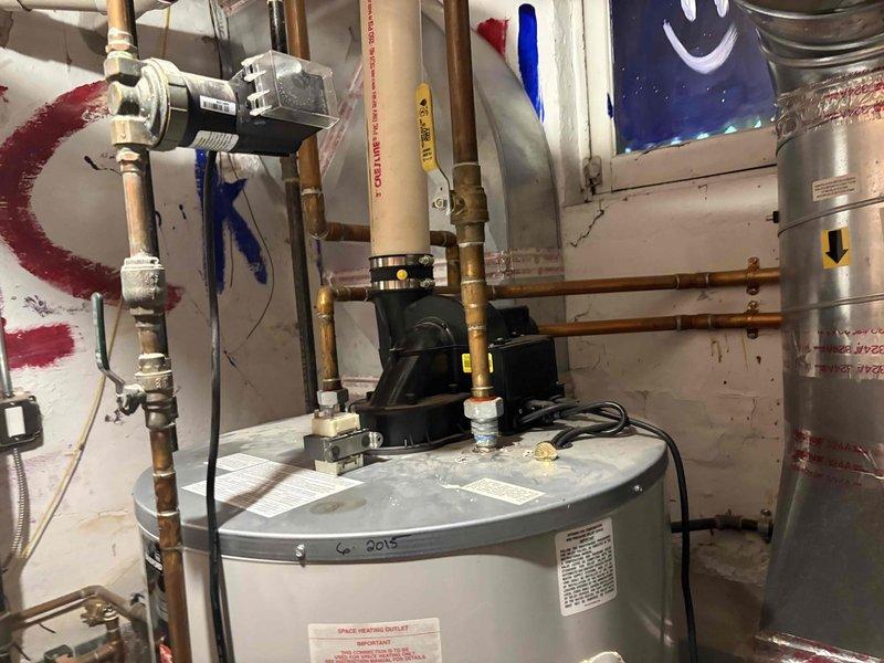 Responded to service call for leaking Bradford White RG2PV75H6N 75-gallon natural gas power-vented water heater. Upon arrival, inspected dual water heater system consisting of the failing 75-gallon unit interconnected with a 2019 Bradford White 50-gallon 40,000-BTU power-vent heater. Evaluated existing potable-water circulator pump and check valve system that provides 125 gallons of combined heated storage capacity. Documented current installation configuration including copper piping connections, isolation valves, and integration points between both units. Assessed power venting system and verified BTU ratings and gas supply lines. Photographed existing equipment, piping layout, circulator pump mounting, and connection points for replacement planning. Provided detailed assessment for complete replacement of leaking 75-gallon heater including reconnection and rebalancing of dual-heater system, evaluation of circulator and check valve replacement needs, and addition of appropriate isola