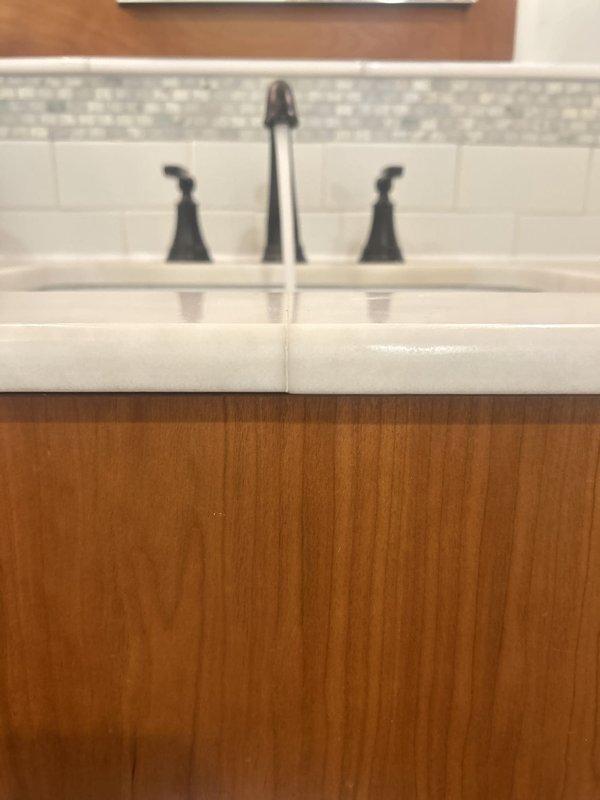 Replaced two bathroom sink faucets with new three-piece oil-rubbed bronze fixtures featuring widespread configuration with separate spout and handle assemblies. Repaired dripping bathroom faucet by servicing worn internal components, restoring proper water flow and eliminating leak.