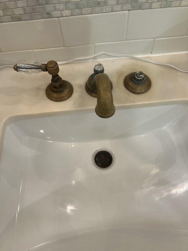 Replaced two bathroom sink faucets with new three-piece oil-rubbed bronze fixtures featuring widespread configuration with separate spout and handle assemblies. Repaired dripping bathroom faucet by servicing worn internal components, restoring proper water flow and eliminating leak.