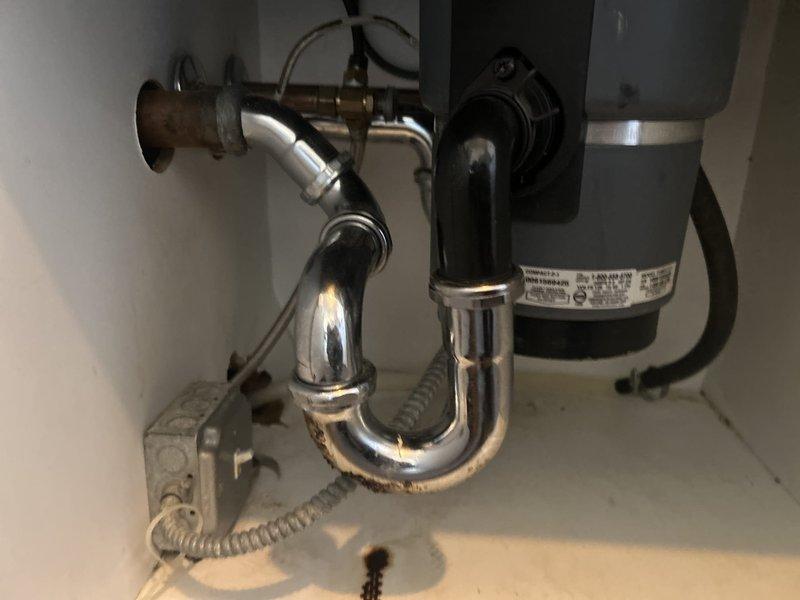 Responded to service call for corroding pipe replacement under kitchen sink. Upon inspection, identified deteriorated copper supply line requiring replacement. Removed old corroded piping and installed new chrome P-trap assembly, ensuring proper connections to existing garbage disposal unit and drain system. Verified all connections were secure, tested for leaks, and confirmed proper drainage function before completing the service.