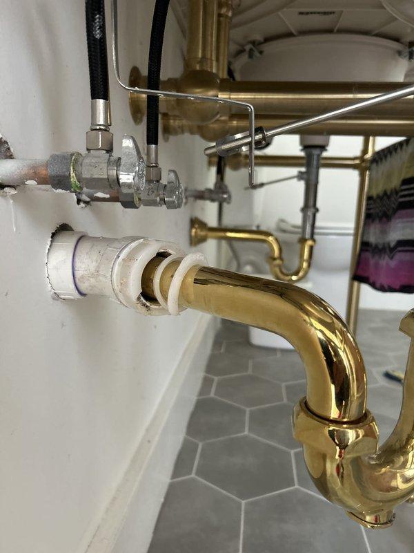 Responded to residential water leak at bathroom vanity sink. Upon inspection, identified active leak originating from supply line connections beneath undermount sink basin. Leak was causing water accumulation around P-trap assembly and dripping onto hexagonal tile flooring. Tightened compression fittings on flexible supply lines connected to shut-off valves, ensuring proper seal at both hot and cold water connections. Inspected brass P-trap and PVC drain assembly for additional leaks or loose connections; all drain components found secure with no evidence of drainage issues. Verified proper operation of brass faucet fixture and tested water flow at full pressure. Monitored all connections for several minutes to confirm leak was fully resolved with no residual dripping. Cleaned work area and confirmed all plumbing fixtures functioning properly before completion.