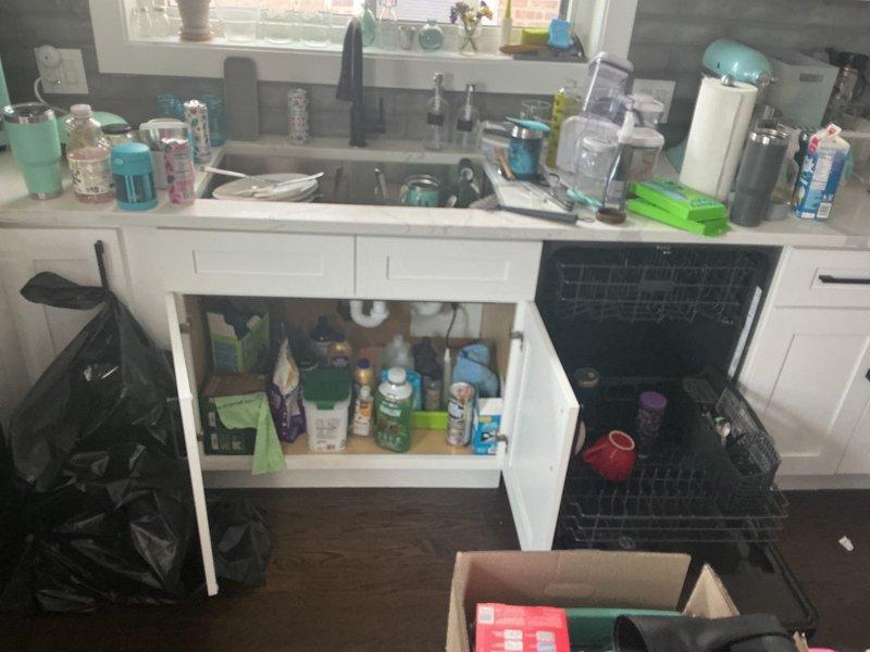 Completed installation of new sewer line plumbing connections beneath residential bathroom vanity sink. Configured white PVC P-trap assembly with chrome drain fittings and stainless steel basket strainer, ensuring proper drainage and code-compliant installation for dual-basin sink system.