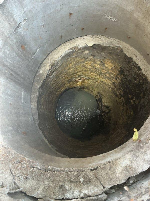 Performed sewer line camera inspection on ranch house to investigate suspected line break near street. Customer reported no current backups but wanted to verify line integrity. Accessed main sewer line through exterior cleanout and conducted video inspection from property toward street connection. Camera inspection revealed aging concrete manhole structure with significant interior deterioration, mineral deposits, and standing water accumulation at base. Interior walls showed extensive staining patterns and moisture damage consistent with long-term use and potential infiltration issues. Documented street-side infrastructure including manhole location in roadway. Inspection confirmed presence of deteriorated concrete components requiring attention. Provided video documentation and photographic evidence of findings for customer review and future repair planning.