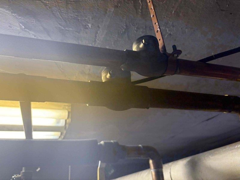 Conducted on-site assessment for water heater replacement in 12-unit residential building experiencing complete loss of hot water. Inspected existing tank-style water heater system installed in 2009, documented plumbing connections including ball valve shutoff with yellow lever handle and copper supply lines, and photographed current installation configuration to prepare comprehensive replacement estimate.