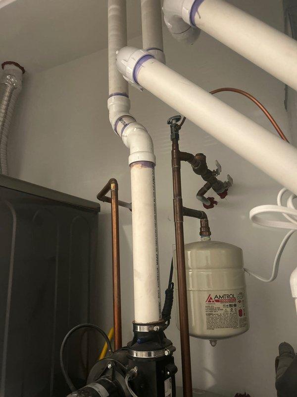Responded to service call for continuously running pump motor in 9-unit building where previous technicians had identified suspected leak in system. Conducted thorough inspection of plumbing infrastructure, including copper supply lines, PVC drainage system, circulation pump assembly, and expansion tank. Documented existing conditions showing aged copper piping with oxidation, pump motor with metallic couplings, AMTROL expansion tank, and multiple pipe connections throughout mechanical room. Photographed system configuration to track potential leak sources and verify component conditions for ongoing warranty diagnostics.