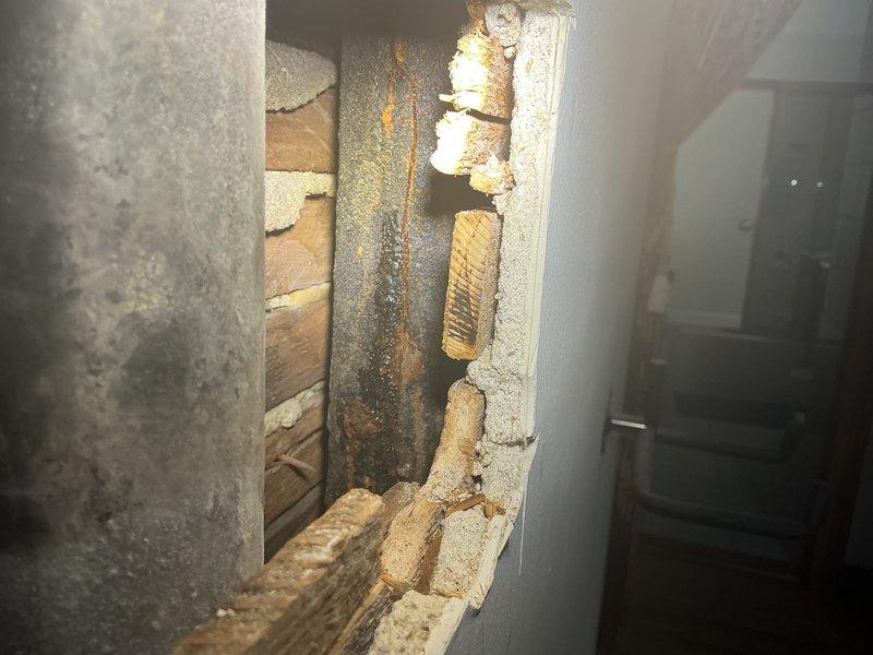 Responded to emergency plumbing call for cracked vertical waste stack in three-flat building causing water infiltration into basement. Upon inspection, identified severely corroded cast iron drain stack running between first and second floors with visible cracking and rust damage extending several feet in both directions from access point. The deteriorated pipe had been actively leaking for multiple days, resulting in continuous water discharge into the basement area. Documented extensive corrosion on the vertical stack pipe and surrounding structural components through the opened wall cavity. Assessed the full extent of damage to determine replacement requirements for the affected section of the drainage system and provided estimate for stack replacement work to restore proper drainage function and prevent further water damage to the property.