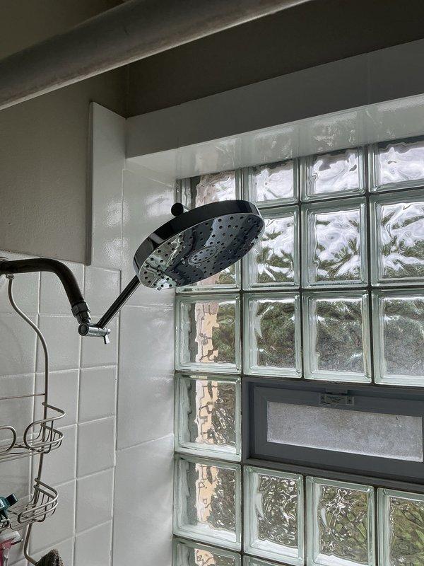 Responded to service call for multiple plumbing leaks affecting toilet, sink, and bathtub fixtures. Inspected bathroom plumbing system and identified sources of water leakage at each fixture. Documented existing conditions of bathtub area with wall-mounted three-handle faucet assembly and tub spout, as well as shower area with overhead fixture and glass block window installation.