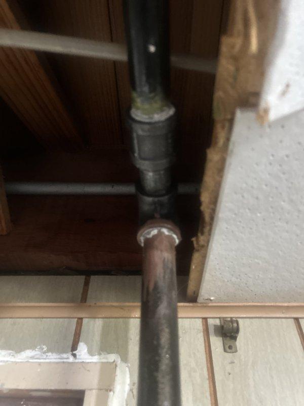 Responded to gas odor complaint near kitchen stove during oven preheat operation. Conducted comprehensive gas leak inspection throughout the premises, focusing on basement utility area near water heater and dryer as previously identified by another contractor. Performed pressure testing on gas supply lines to locate and verify leak source. Inspected all gas pipe connections, fittings, and joints in the affected areas. Documented existing pipe conditions, including visible corrosion and deterioration at threaded connections on gas supply piping. Identified compromised pipe joint requiring immediate repair to eliminate gas leak hazard and restore system integrity.