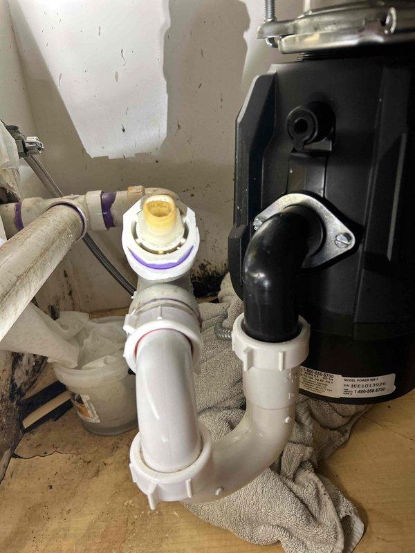 Responded to kitchen sink leak complaint and performed diagnostic inspection of under-sink plumbing assembly. Located source of leak at garbage disposal connection point and drain pipe fittings. Tightened disposal mounting hardware and replaced deteriorated gasket seal at disposal discharge connection. Inspected all PVC drain pipe joints and connections for proper sealing. Tested system under full water flow to verify leak resolution and confirm proper drainage function.