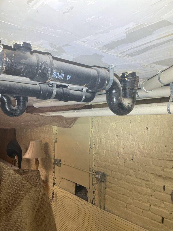 Conducted site assessment for grease trap installation in commercial kitchen area. Evaluated existing three-compartment stainless steel sink configuration and current drainage system. Inspected basement plumbing infrastructure including overhead drain lines and floor access points. Provided estimate for concrete floor removal and installation of new drain connection to properly integrate grease trap into existing wastewater system.