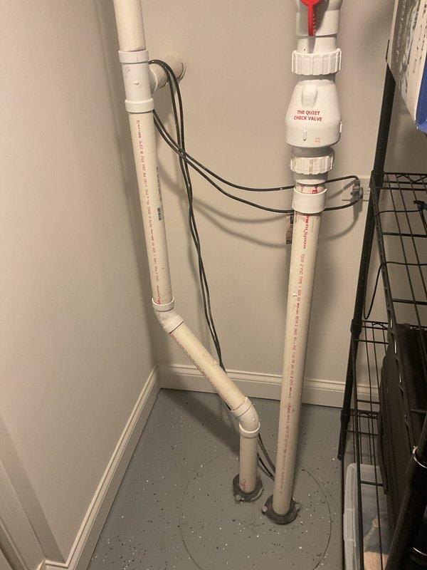 Conducted on-site evaluation of existing sump pump system to assess equipment condition and provide estimate for battery backup installation. Inspected current Jackel JP550T submersible sewage pump (1/2 HP, 120V) manufactured in January 2019, including examination of discharge piping configuration with PVC vertical runs, quiet check valve assembly, and electrical wiring routing. Documented existing plumbing installation featuring dual vertical discharge pipes with proper valve placement and cable management to determine compatibility requirements for battery backup system integration and assess whether pump replacement would be necessary based on equipment age and operational condition.