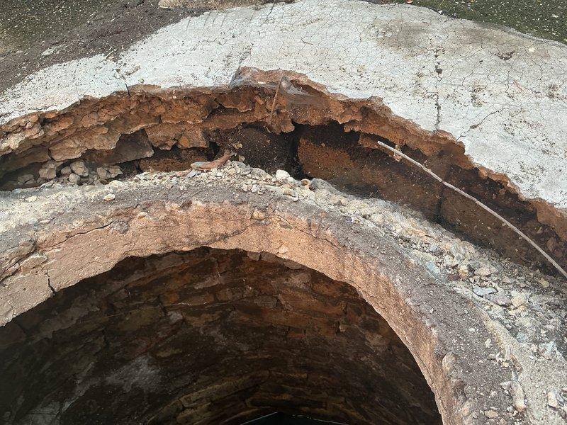 Responded to service call for catch basin repair assessment. Upon arrival, inspected exterior catch basin access point and internal structure. Documented extensive deterioration of concrete catch basin components, including severe cracking, structural separation, and significant corrosion of internal reinforcement materials. Access cover showed advanced weathering with paint failure and wood deterioration. Internal inspection revealed compromised concrete integrity with visible voids, exposed rusted rebar, and multiple fracture points throughout the basin structure. Photographed all damage for estimate preparation and provided homeowners with detailed assessment of necessary repairs to restore proper drainage function and structural integrity.