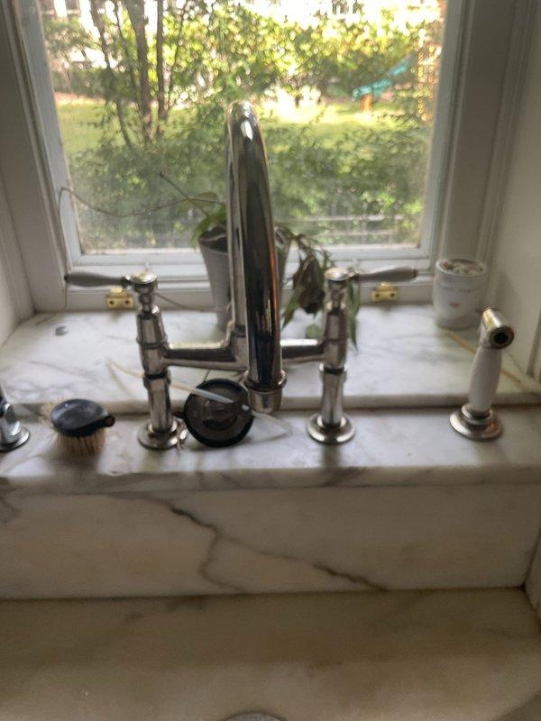 Completed faucet installation in kitchen and bathroom. Kitchen work included installing new chrome faucet assembly with dual handles and integrated soap dispenser on white counter surface. Bathroom service involved faucet replacement on round gray basin with updated single-handle chrome fixture. Removed old hardware, installed new mounting brackets, connected water supply lines, and tested both fixtures for proper operation and leak-free performance.