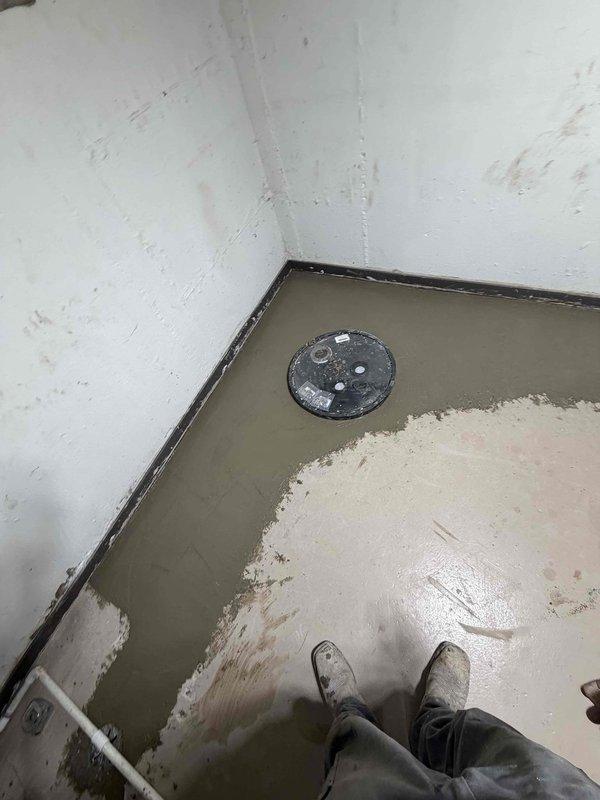 Responded to flooding emergency in basement utility room with several inches of standing water accumulation. Assessed drainage system and floor drain functionality to identify source of water intrusion. Inspected outdoor septic or water management tank system with multiple access ports, verified PVC discharge line connections, and documented condition of installation in gravel bed to ensure proper drainage operation and prevent future flooding incidents.