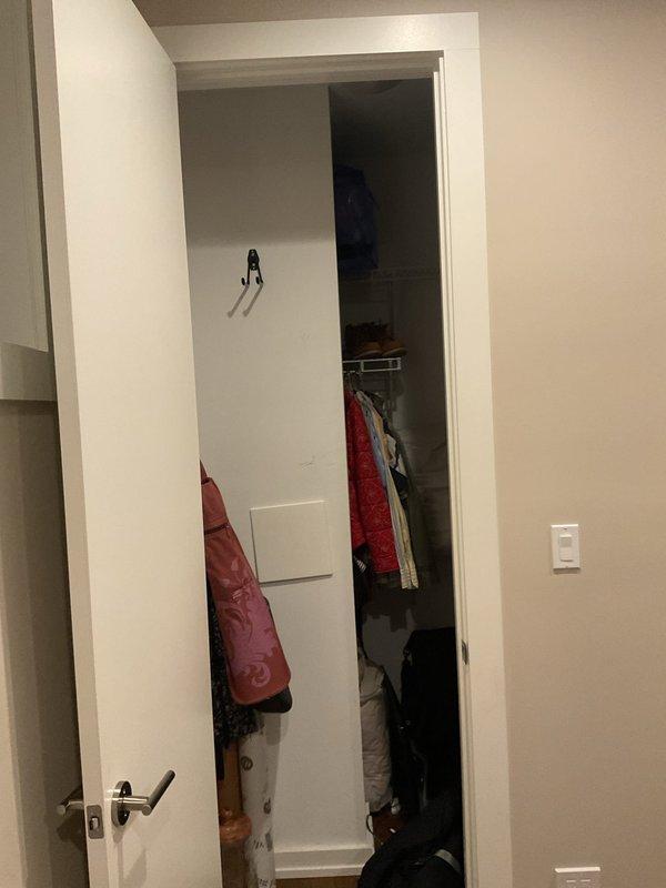 Responded to customer complaint of floor drain backing up in residential unit. Upon arrival, accessed the affected area through interior hallway near bedroom and closet space. Inspected floor drain location and assessed drainage system for blockages or obstructions causing the backup condition. Documented site conditions with photographs for service records.