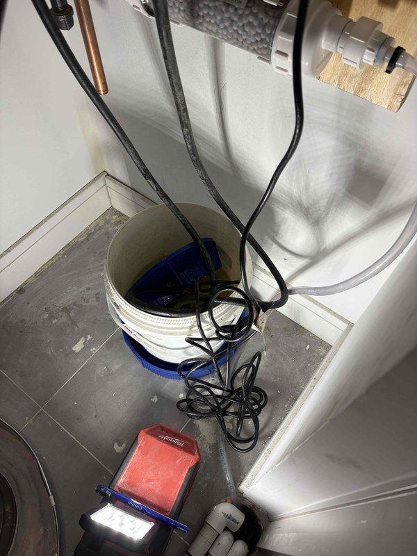 Performed annual maintenance flush on tankless water heater unit. Connected submersible pump with circulation hoses to service valves and circulated descaling solution through the heat exchanger to remove mineral buildup and sediment accumulation. Flushed system with clean water to remove all cleaning solution residue, inspected inlet filter screen, and verified proper flow rates and operational performance upon completion.