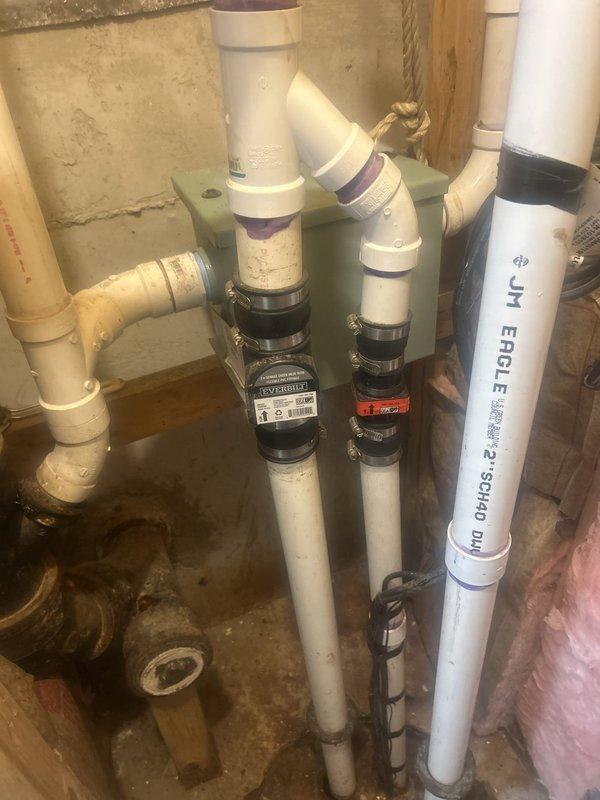 Responded to service call for sump pump replacement in basement utility area. Upon arrival, contacted tenant as requested and assessed existing sump pit system with battery backup. Inspected current installation including PVC discharge piping (Schedule 40), check valve assembly, and electrical connections. Documented existing plumbing configuration showing vertical discharge lines secured with mounting brackets, green metal support structure, and multiple PVC connections with rubber couplings. Noted moisture staining on concrete floor around pit area indicating previous water activity. Photographed complete system setup including pipe routing through unfinished space with visible insulation and electrical junction box. Prepared detailed estimate for pit sump pump and battery backup replacement, documenting all necessary components and labor requirements for owner approval before proceeding with installation work.