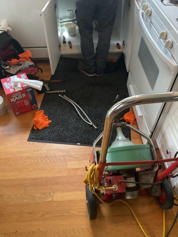Responded to kitchen sink backup with approximately 1.5 inches of thick, mud-like material that had accumulated overnight in the basin. Upon arrival, accessed the cabinet beneath the sink and deployed drain cleaning equipment to clear the blockage. Successfully removed the obstruction and restored proper drainage to the kitchen sink, eliminating the backup condition.