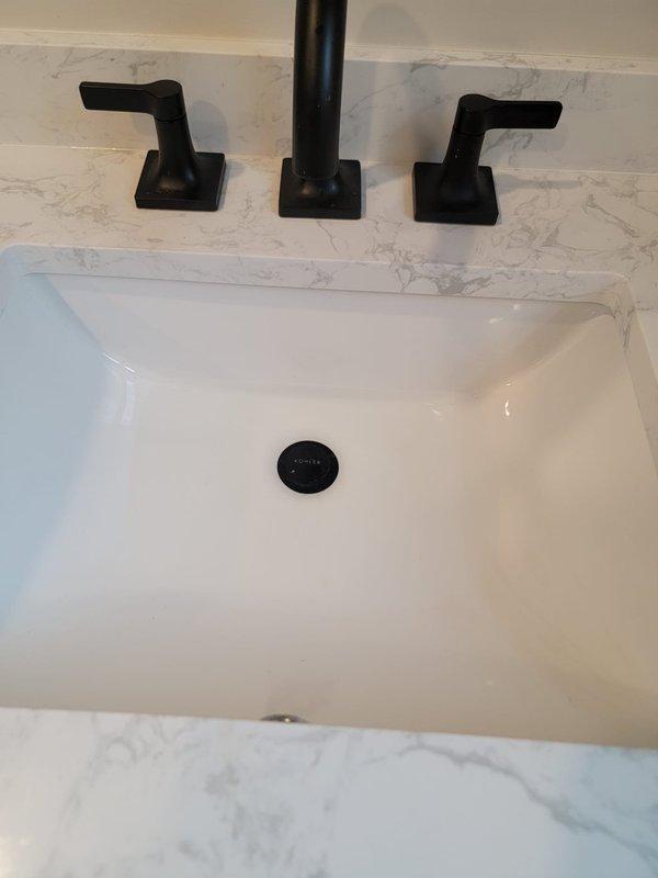 Responded to slow-draining bathroom sink and floor drain. Cleared blockage from drain lines using professional drain cleaning equipment, restoring proper water flow to both the undermount sink with its pop-up drain assembly and the decorative mosaic tile floor drain. Both fixtures now draining at normal speed with no standing water remaining.